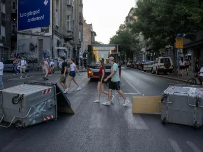 People walk past barricades during road blockades organised by students and anti-government demonstrators demanding snap elections and release of detained protestors, in Belgrade, Serbia, June 30, 2025. REUTERS/Marko Djurica