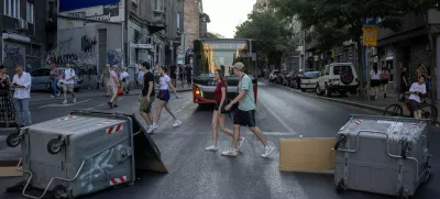 People walk past barricades during road blockades organised by students and anti-government demonstrators demanding snap elections and release of detained protestors, in Belgrade, Serbia, June 30, 2025. REUTERS/Marko Djurica