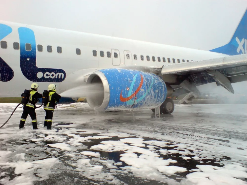Firefighters spray foam on the engine of a Boeing 737-800 of the German company XL Airways on the tarmac of Nikola Tesla Airport in Belgrade October 18, 2008. A plane carrying 169 people on a flight from Germany to Turkey made an emergency landing at Belgrade on Saturday after an engine failure, an aviation official said. A spokesman for Belgrade airport said the Boeing 737-800 with 163 passengers and six crew on board made an emergency landing at 7:47 a.m. (0547 GMT). REUTERS/Serbian Interior Ministry/Handout (SERBIA). FOR EDITORIAL USE ONLY. NOT FOR SALE FOR MARKETING OR ADVERTISING CAMPAIGNS.