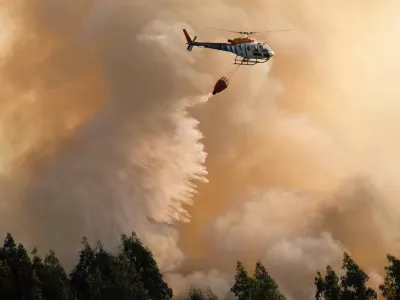 A firefighting helicopter drops its load of water on a forest fire near Santa Comba Dao, northern Portugal, Thursday, Aug. 11 2016. Firefighters in Portugal are battling multiple blazes fed by brush in a hot, dry summer for a sixth straight day. Major fires have also been raging in northwestern Spain and southern France. (AP Photo/Sergio Azenha)
