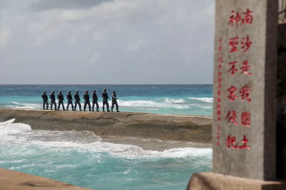 Soldiers of China's People's Liberation Army (PLA) Navy patrol near a sign in the Spratly Islands, known in China as the Nansha Islands, February 9, 2016. The sign reads "Nansha is our national land, sacred and inviolable." REUTERS/Stringer/File Photo ATTENTION EDITORS - THIS PICTURE WAS PROVIDED BY A THIRD PARTY. THIS PICTURE IS DISTRIBUTED EXACTLY AS RECEIVED BY REUTERS, AS A SERVICE TO CLIENTS. CHINA OUT. NO COMMERCIAL OR EDITORIAL SALES IN CHINA. FROM THE FILES PACKAGE - SEARCH "SOUTH CHINA SEA FILES" FOR ALL IMAGES   TPX IMAGES OF THE DAY