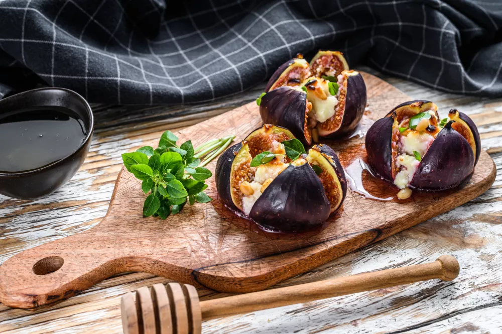 Oven-baked figs with gorgonzola, herbs and honey. White background. Top view. / Foto: Vladimir Mironov