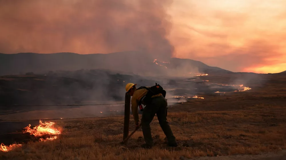 A firefighter works to tackle the Madre Fire near New Cuyama, California, U.S. July 3, 2025. REUTERS/David Swanson