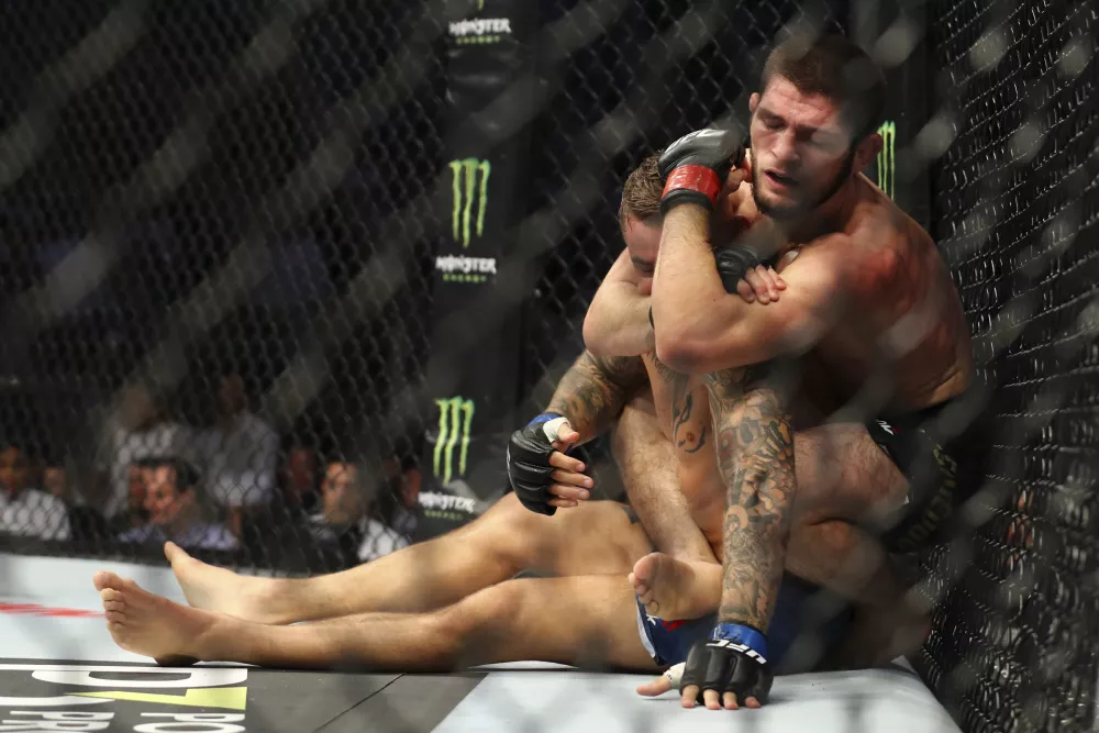 Russian UFC fighter Khabib Nurmagomedov, choke holds UFC fighter Dustin Poirier, of Lafayette, La., during Lightweight title mixed martial arts bout at UFC 242, in Yas Mall in Abu Dhabi, United Arab Emirates, Saturday, Sept.7 2019. (AP Photo/ Mahmoud Khaled)
