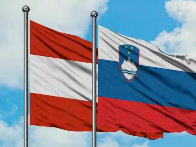 Austria and Slovenia flag waving in the wind against white cloudy blue sky together. Diplomacy concept, international relations.
