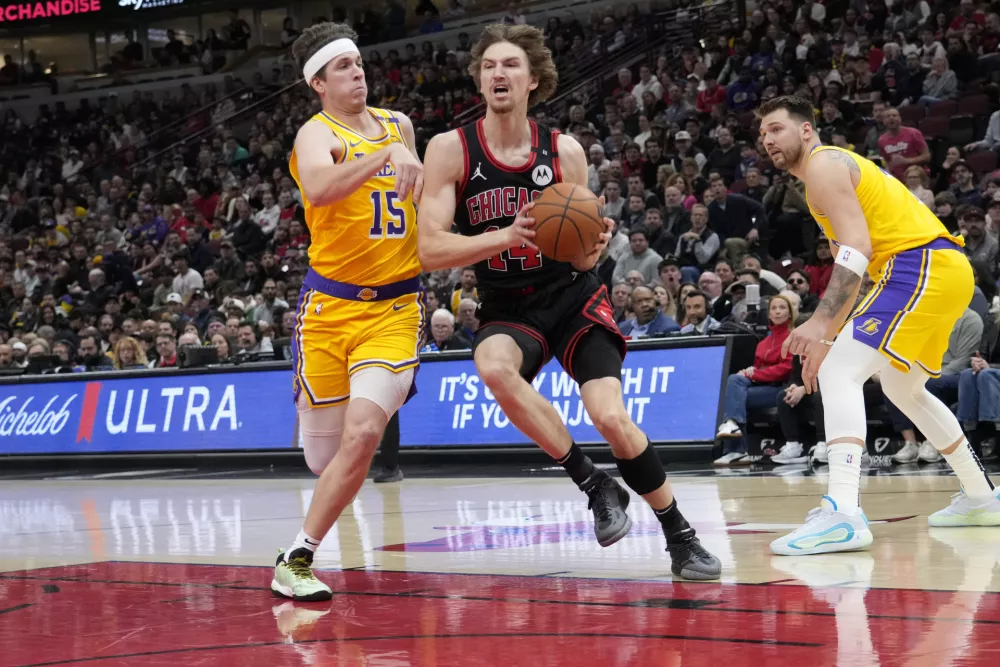 Mar 27, 2025; Chicago, Illinois, USA; Los Angeles Lakers guard Austin Reaves (15) defends Chicago Bulls forward Matas Buzelis (14) during the first quarter at United Center. Mandatory Credit: David Banks-Imagn Images