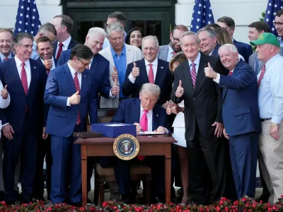 U.S. President Donald Trump signs a sweeping spending and tax legislation, known as the "One Big Beautiful Bill Act," during a picnic with military families to mark Independence Day, at the White House in Washington, D.C., U.S., July 4, 2025. REUTERS/Ken Cedeno