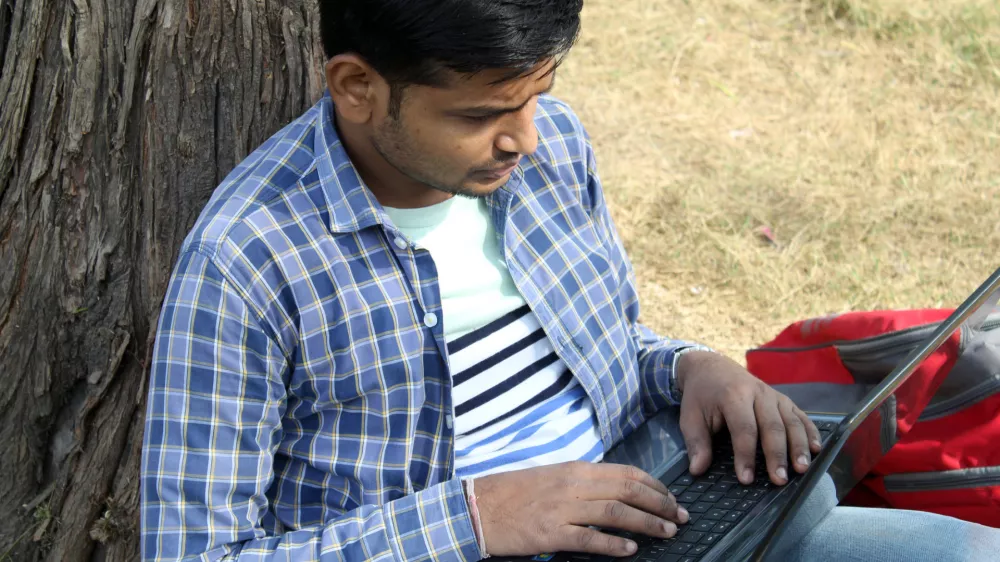 indian man using laptop at the park / Foto: Vipin Jaiswal