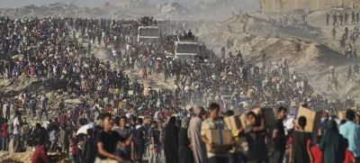 Palestinians carry sacks and boxes of food and humanitarian aid, unloaded from a World Food Program convoy that was heading to Gaza City in the northern Gaza Strip, Monday, June 16, 2025. (AP Photo/Jehad Alshrafi)