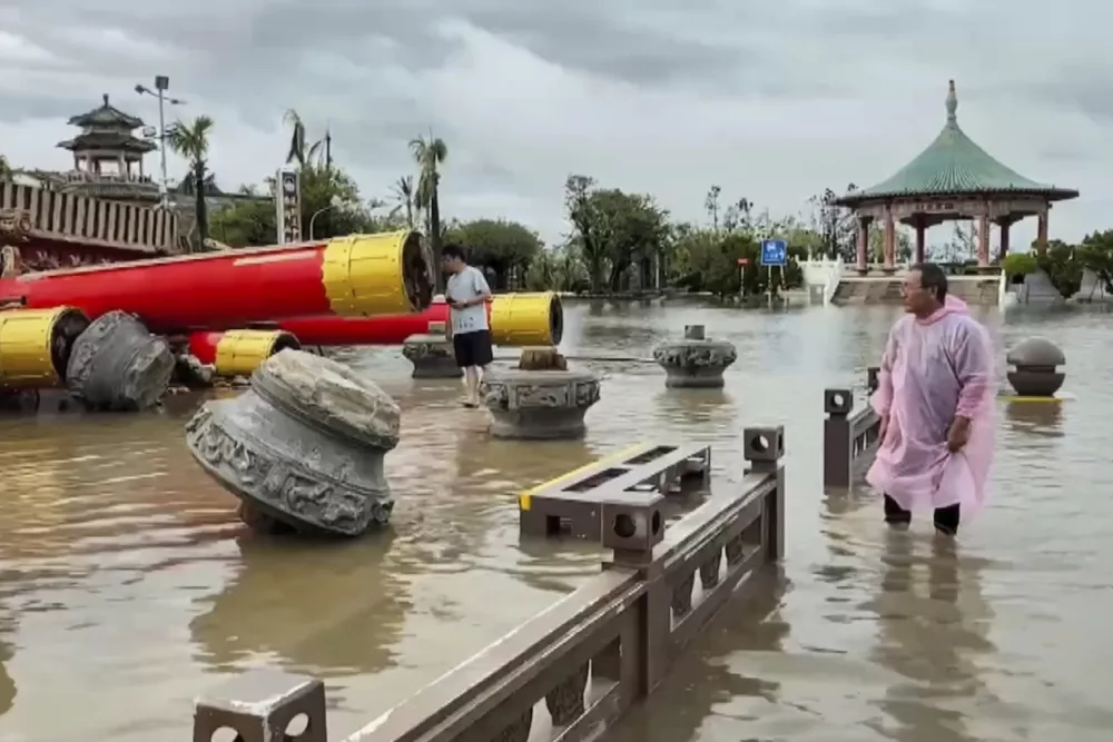 In this image made from a video provided by TVBS, residents look at the collapsed temple structures submerged in floodwaters Monday, July 7, 2025, after the Typhoon Danas landed in Tainan, Taiwan. (TVBS via AP)