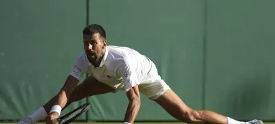 Serbia's Novak Djokovic returns to Italy's Flavio Cobolli during a quarterfinal men's singles match at the Wimbledon Tennis Championships in London, Wednesday, July 9, 2025. (AP Photo/Kin Cheung)
