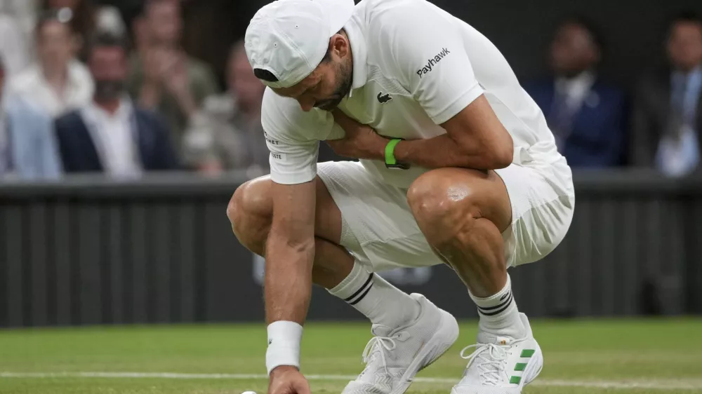 Bulgaria's Grigor Dimitrov clutches his chest with an injury which forced him to retire injured from a fourth round men's singles match against Italy's Jannik Sinner at the Wimbledon Tennis Championships in London, Monday, July 7, 2025. (AP Photo/Kin Cheung)