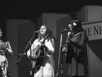 American singer, songwriter, musician and activist Joan Baez American singer-songwriter and activist Mimi Farina (1945 - 2001) and Judy Collins at Newport Folk Festival 15th July 1967. (Photo by John Byrne Cooke Estate/Getty Images)