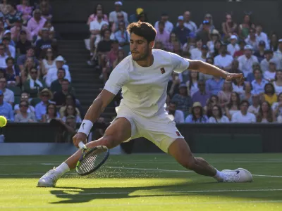 Spain's Carlos Alcaraz returns to Britain's Cameron Norrie during a quarterfinal men's singles match at the Wimbledon Tennis Championships in London, Tuesday, July 8, 2025. (AP Photo/Kirsty Wigglesworth)