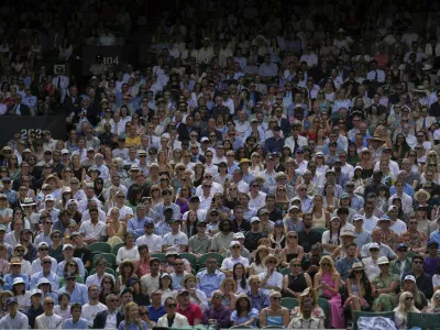 Spectators pack the stands of Centre Court as Switzerland's Belinda Bencic plays Mirra Andreeva of Russia during a quarterfinal women's singles match between at the Wimbledon Tennis Championships in London, Wednesday, July 9, 2025. (AP Photo/Kin Cheung)