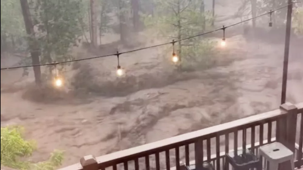 In this image taken from video, flash flooding is seen behind a house in Ruidoso, N.M., Tuesday, July 8, 2025. (Kaitlyn Carpenter via AP)