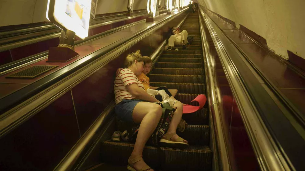 A mother with her daughter sleeps on the stairs of a metro station as they take cover during a Russian attack on Kyiv, Ukraine, on Thursday, July 10, 2025. (AP Photo/Evgeniy Maloletka)