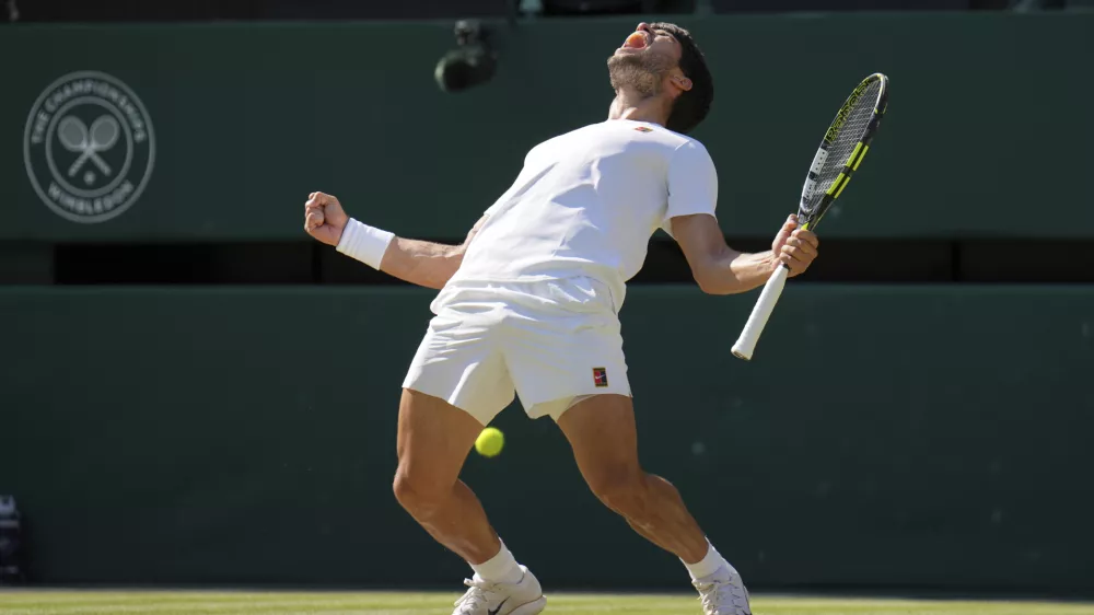 Spain's Carlos Alcaraz celebrates after beating Taylor Fritz of the U.S. in a men's singles semifinal at the Wimbledon Tennis Championships in London, Friday, July 11, 2025. (AP Photo/Kin Cheung)