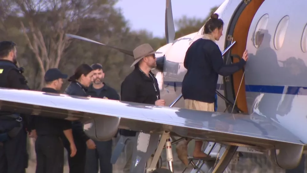SCREENSHOT - 11 July 2025, Australia, ---: A screenshot from an ABC television video shows Carolina Wilga (R) boarding a plane. A German backpacker who had been missing for 12 days in remote bushland has been found alive by emergency services. Photo: -/ABC via AAP/dpa - ACHTUNG: Nur zur redaktionellen Verwendung und nur mit vollst&auml;ndiger Nennung des vorstehenden Credits / Foto: -