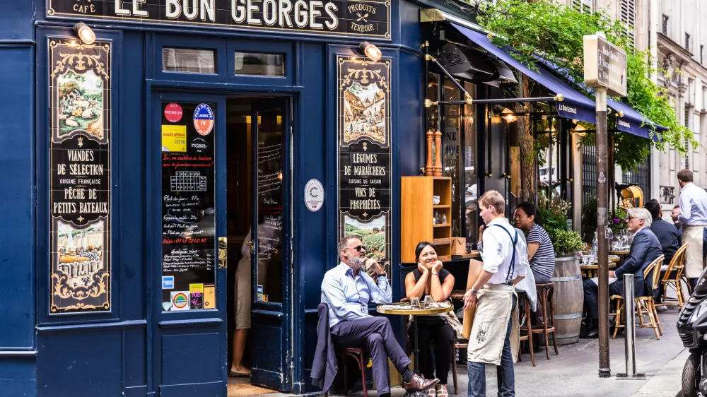 Paris, France - June 16, 2017: The charming Cafe Le Bon Georges. Parisians and tourists enjoy food and drinks at the street french cafe.