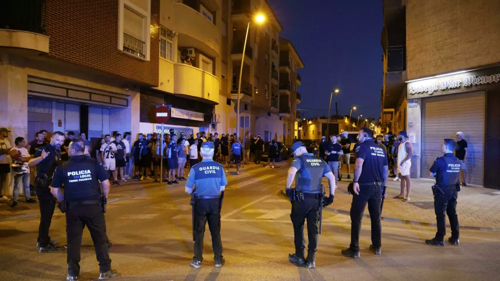 Local police officers and Spanish civil guard agents take positions during the disturbances in Torre Pacheco, eastern Spain, Friday, July 12, 2025. (Mart&iacute;n C./Europa Press via AP)