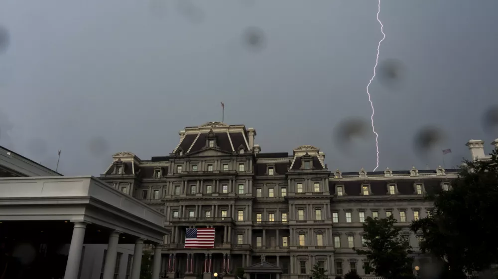 A bolt of lightning comes down behind the Eisenhower Executive Office Building on the White House complex, Monday, July 14, 2025, in Washington. (AP Photo/Alex Brandon)