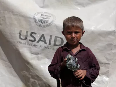 FILE PHOTO: Sajad, 7, who has been displaced by flooding, holds his toy jeep outside his family tent with the weather sheet donated by USAID, while taking refuge on an embankment near Kari Mori, some 32 km (20 miles) from Dadu, in Pakistan's Sindh province October 5, 2010. REUTERS/Akhtar Soomro/File Photo
