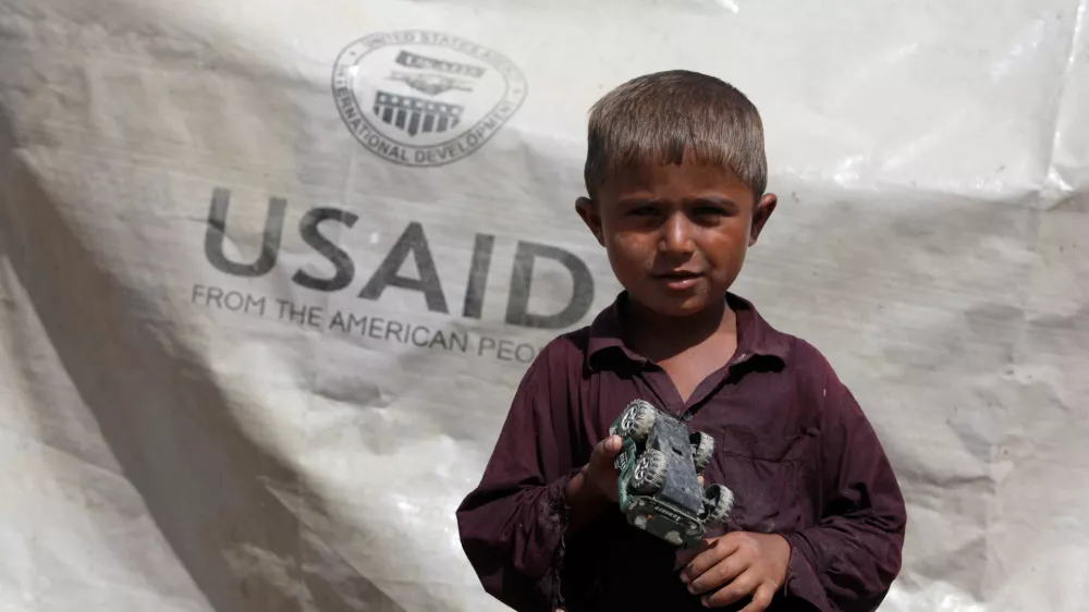 FILE PHOTO: Sajad, 7, who has been displaced by flooding, holds his toy jeep outside his family tent with the weather sheet donated by USAID, while taking refuge on an embankment near Kari Mori, some 32 km (20 miles) from Dadu, in Pakistan's Sindh province October 5, 2010. REUTERS/Akhtar Soomro/File Photo