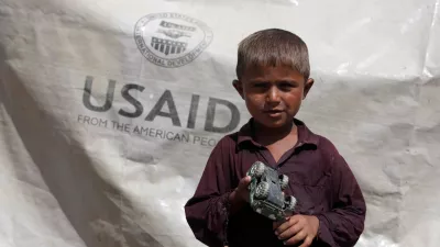 FILE PHOTO: Sajad, 7, who has been displaced by flooding, holds his toy jeep outside his family tent with the weather sheet donated by USAID, while taking refuge on an embankment near Kari Mori, some 32 km (20 miles) from Dadu, in Pakistan's Sindh province October 5, 2010. REUTERS/Akhtar Soomro/File Photo