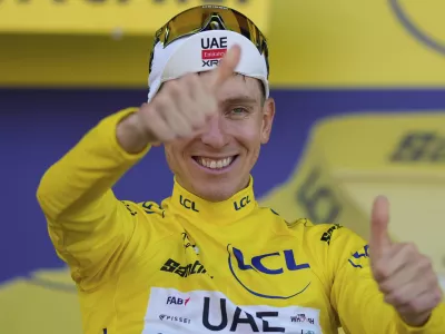Stage winner Slovenia's Tadej Pogacar celebrates taking the yellow jersey after the twelfth stage of the Tour de France cycling race over 180.6 kilometers (112.2 miles) with start in Auch and finish in Hautacam, France, Thursday, July 17, 2025. (AP Photo/Mosa'ab Elshamy)