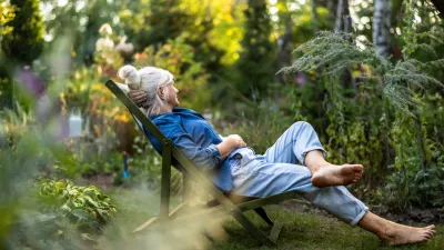 Mature woman relaxing in deckchair in her garden / Foto: Piksel