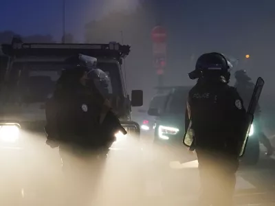18 July 2025, France, Gravelines: French riot police clash with people thought to be migrants in France's Gravelines, as they were trying to board a dinghy to cross into the UK. Photo: Gareth Fuller/PA Wire/dpa