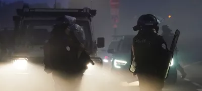 18 July 2025, France, Gravelines: French riot police clash with people thought to be migrants in France's Gravelines, as they were trying to board a dinghy to cross into the UK. Photo: Gareth Fuller/PA Wire/dpa