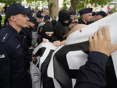 Police officers try to separate and secure a small group of counter-demonstrators who attempt to block the anti-immigration demonstration Confederation party and soccer hooligans in Warsaw, Poland, Saturday, July 19, 2025. (AP Photo/Czarek Sokolowski)