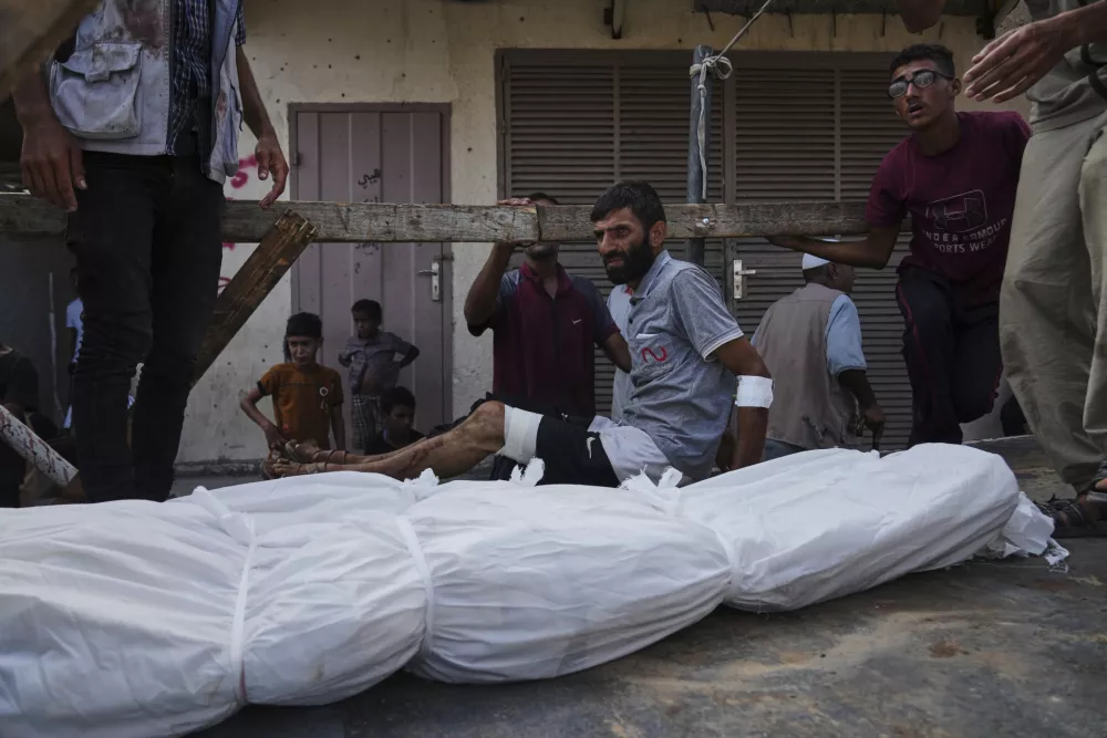 Mourners attend the funeral of their relatives killed in an Israeli bombardment, in Deir al-Balah, central Gaza Strip, Monday, July 21, 2025. (AP Photo/Abdel Kareem Hana)