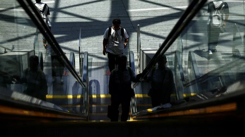Poople ride the escalator as the Japanese government issued a heatstroke alert in Tokyo and other prefectures, in Tokyo, Japan July 22, 2025. REUTERS/Issei Kato   TPX IMAGES OF THE DAY / Foto: Issei Kato
