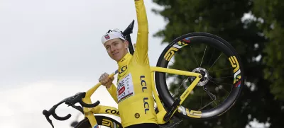Cycling - Tour de France - Stage 21 - Mantes-la-Ville to Paris - Paris, France - July 27, 2025 UAE Team Emirates XRG's Tadej Pogacar celebrates on the podium with his bike while wearing the yellow jersey after winning the Tour de France REUTERS/Benoit Tessier