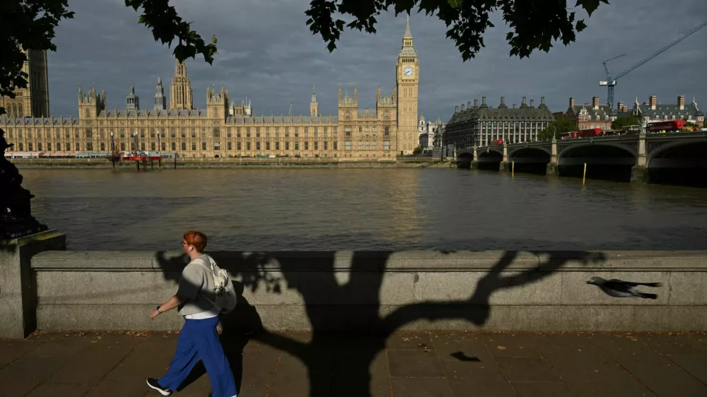 A woman walks by the River Thames with a view of Big Ben and the Houses of Parliament London, Britain, July 28, 2025. REUTERS/Jaimi Joy