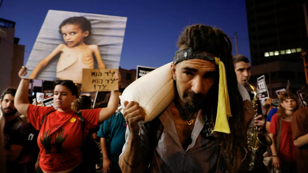 A demonstrator carries a sack of flour, during a protest demanding an end to the war in Gaza and the release of all hostages, in Tel Aviv, Israel, July 22, 2025. REUTERS/Ammar Awad   TPX IMAGES OF THE DAY / Foto: Ammar Awad