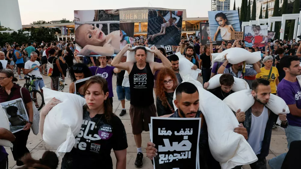 Demonstrators carry sacks of flour, during a protest demanding an end to the war in Gaza and the release of all hostages, in Tel Aviv, Israel, July 22, 2025. REUTERS/Ammar Awad