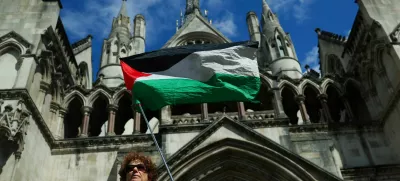 A person holds a Palestinian flag outside the High Court on the day of a hearing about the banned pro-Palestinian campaign organisation Palestine Action, in London, Britain, July 21, 2025. REUTERS/Isabel Infantes