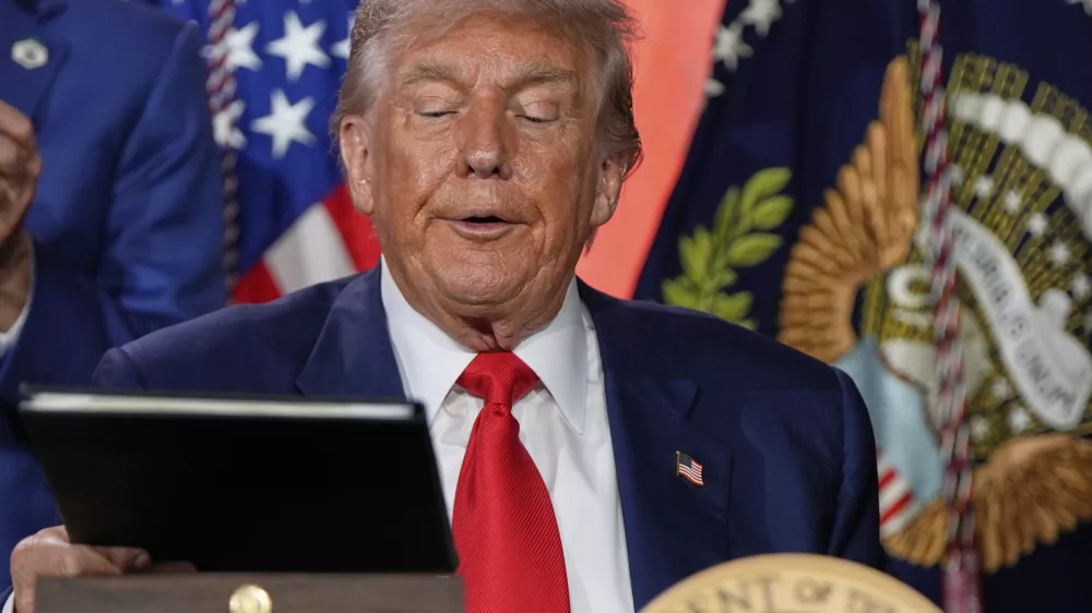 President Donald Trump signs executive orders after speaking during an AI summit at the Andrew W. Mellon Auditorium, Wednesday, July 23, 2025, in Washington. (AP Photo/Julia Demaree Nikhinson)