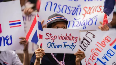 Bangkok, 20 July 2025 &ndash; A protester holds a sign reading "Stop violating Ottawa Treaty" during a nationalist demonstration outside the Cambodian Embassy in Bangkok. Protesters gathered outside the Royal Embassy of Cambodia to denounce Cambodia's alleged use of landmines on Thai territory, following the injury of Thai soldiers near the Chong Bok border area. Authorities claim the mines, recently discovered beyond Cambodia's military line, violate the Ottawa Convention.Bangkok, 20 juillet 2025 &ndash; Une manifestante brandit une pancarte &laquo; Stop violating Ottawa Treaty &raquo; lors d'un rassemblement nationaliste devant l'ambassade du Cambodge a Bangkok. Des manifestants se sont rassembles devant l'Ambassade Royale du Cambodge pour denoncer l'usage presume de mines antipersonnel par le Cambodge sur le territoire thailandais, apres la blessure de soldats thailandais pres de la frontiere de Chong Bok. Les autorites affirment que les mines, recemment decouvertes au-dela de la ligne militaire cambodgienne, enfreignent la Convention d'Ottawa.