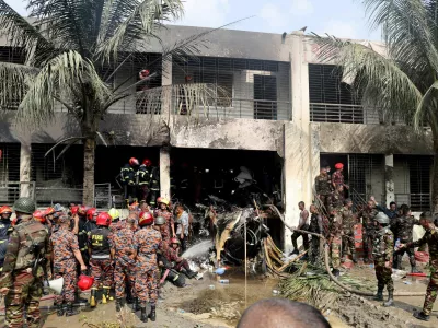 FILE PHOTO: Firefighters and soldiers work next to the wreckage of an air force training aircraft after it crashed into Milestone College campus, in Dhaka, Bangladesh, July 21, 2025. REUTERS/Stringer/File Photo