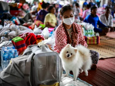 Juam, 50 sits next to her dog "Krati" inside a temporary shelter in Srisaket province, after Thailand and Cambodia exchanged heavy artillery fire for a second day on Friday as border fighting intensified and spread, while Cambodia's leader said Thailand had agreed to a Malaysian ceasefire proposal but then backed down, Thailand, July 26, 2025. REUTERS/Athit Perawongmetha