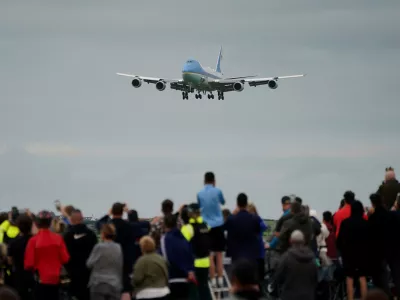Trump supporters watch on as a plane carrying US President Donald Trump arrives at Prestwick Airport, before he begins his five-day private trip to the country, Friday July 25, 2025. (Jane Barlow/PA via AP)