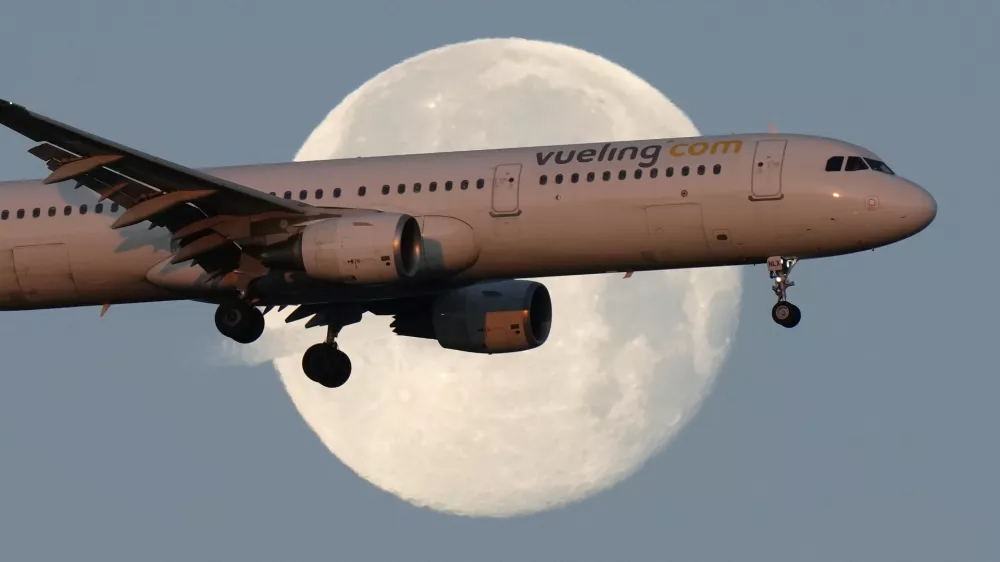 FILE - A Vueling Airbus A321 approaches for landing in Lisbon at sunrise, while the moon sets in the background,, Feb. 7, 2023. (AP Photo/Armando Franca, File)