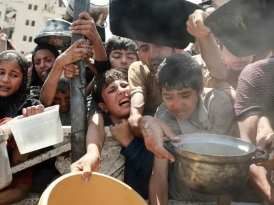 Palestinians wait to receive food from a charity kitchen, amid a hunger crisis, in Gaza City, July 28, 2025. REUTERS/Khamis Al-Rifi