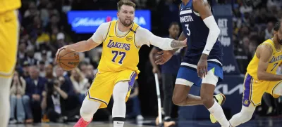 Los Angeles Lakers guard Luka Doncic (77) works toward the basket as Minnesota Timberwolves forward Jaden McDaniels (3) defends during the second half of Game 3 of an NBA basketball first-round playoff series, Friday, April 25, 2025, in Minneapolis. (AP Photo/Abbie Parr)