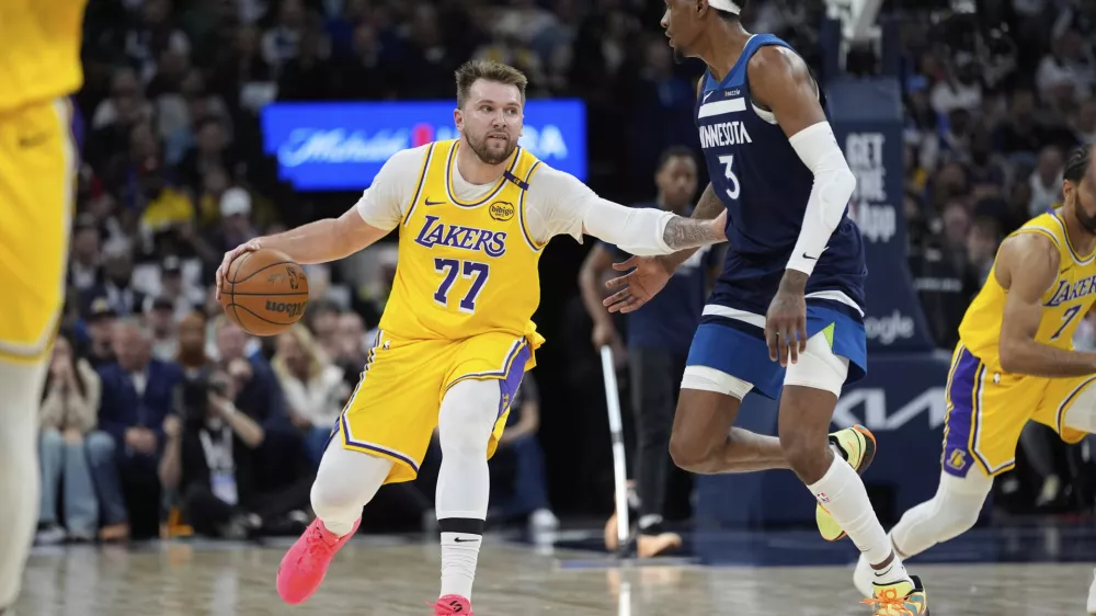 Los Angeles Lakers guard Luka Doncic (77) works toward the basket as Minnesota Timberwolves forward Jaden McDaniels (3) defends during the second half of Game 3 of an NBA basketball first-round playoff series, Friday, April 25, 2025, in Minneapolis. (AP Photo/Abbie Parr)